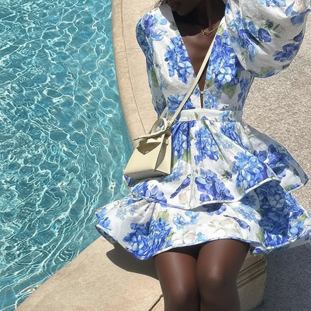 Woman in a blue floral dress by a poolside